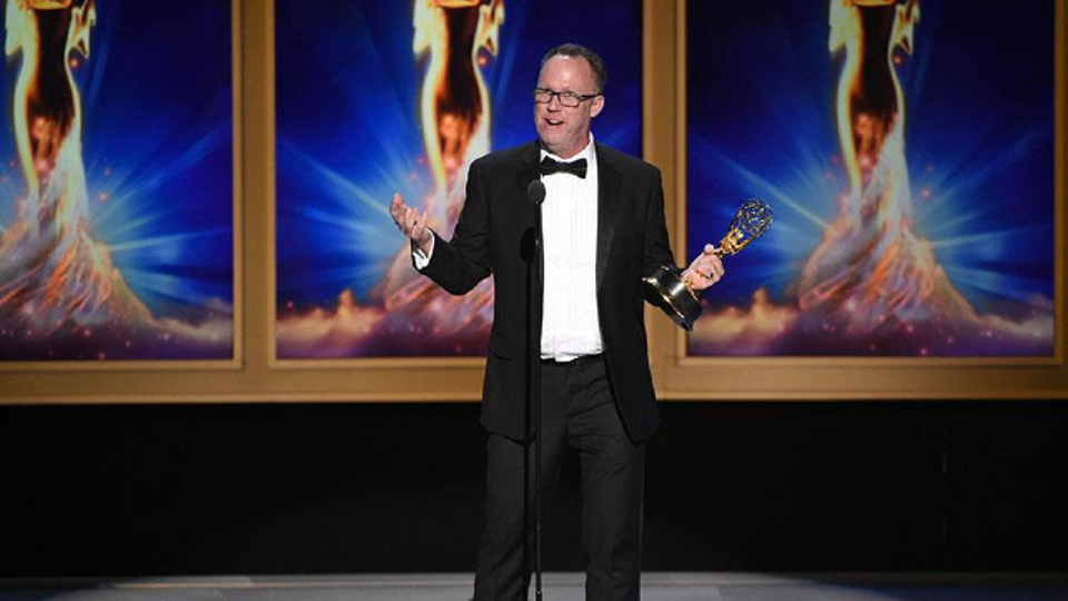 Nick Murray at the Emmy Awards holding his Emmy.